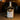 Bottle of Corte Vetusto Mezcal Ancestral on a wooden surface with a blurred background