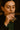 Woman drinking a glass of mezcal with a dark background